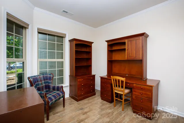 a view of a workspace with furniture and a window