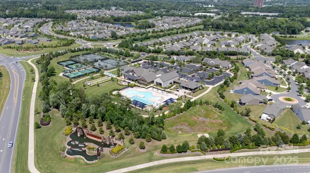 an aerial view of a residential houses with outdoor space and parking