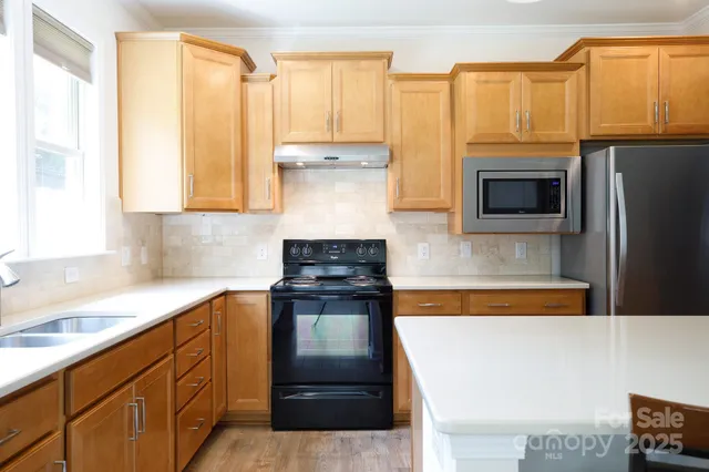a kitchen with stainless steel appliances a stove sink and microwave