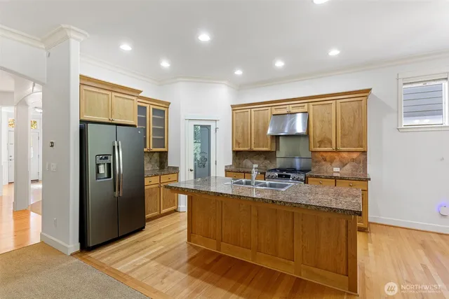 a kitchen with refrigerator cabinets and large window