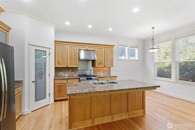 a kitchen with stainless steel appliances granite countertop a sink stove and refrigerator