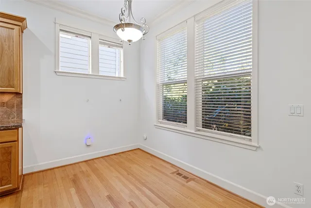 en empty room with wooden floor and windows