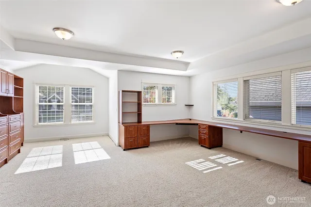 a large white kitchen with granite countertop a large stove a sink and dishwasher next to a window