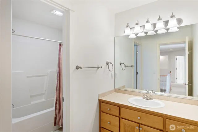 a bathroom with a sink vanity tub and shower