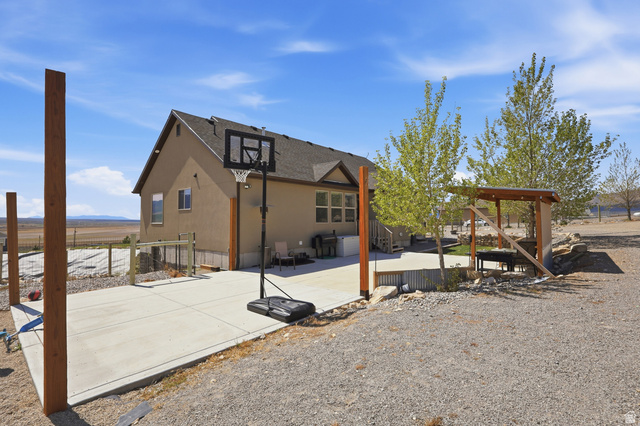 1588 West Rim Rock Drive Stockton, UT 84071 - Photo 41 of 61 Exterior featuring a stucco finish, a concrete patio, and a dedicated concrete slab