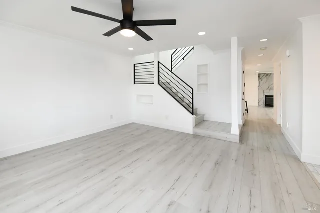 a view of a hallway with wooden floor and staircase