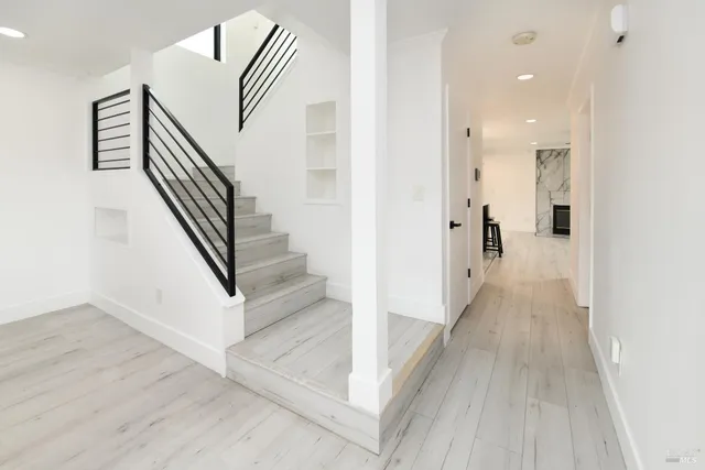 a kitchen with stainless steel appliances kitchen island a refrigerator sink and wooden floor