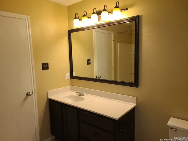 a bathroom with a sink vanity and a mirror
