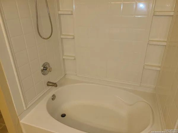 a bathroom with a white bath tub and a shower