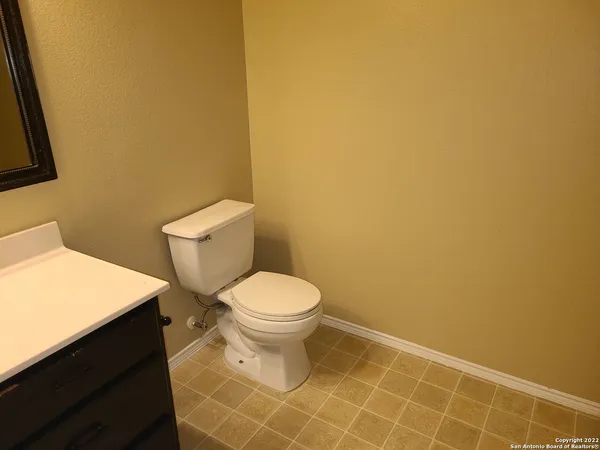 a white toilet sitting next to a white wall