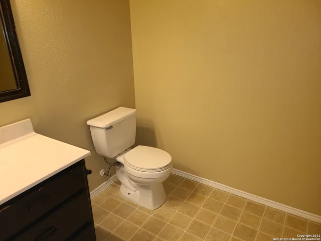 a white toilet sitting next to a white wall