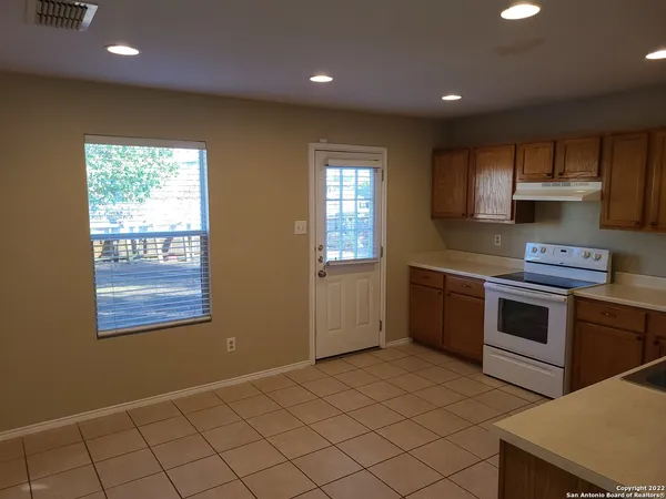 a kitchen with kitchen island granite countertop appliances cabinets and a sink