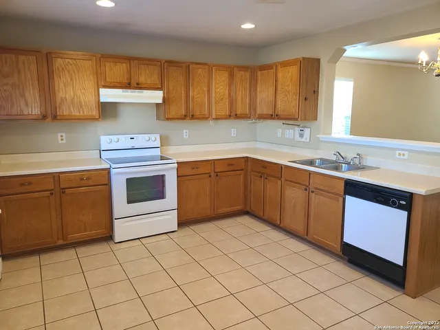 a kitchen with a sink a stove and cabinets