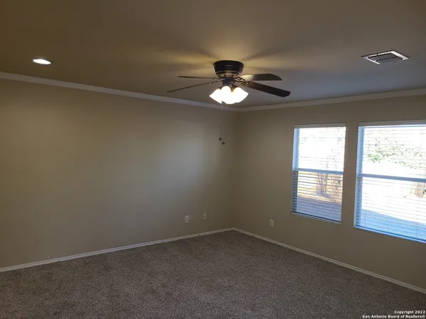 an empty room with a window and a ceiling fan
