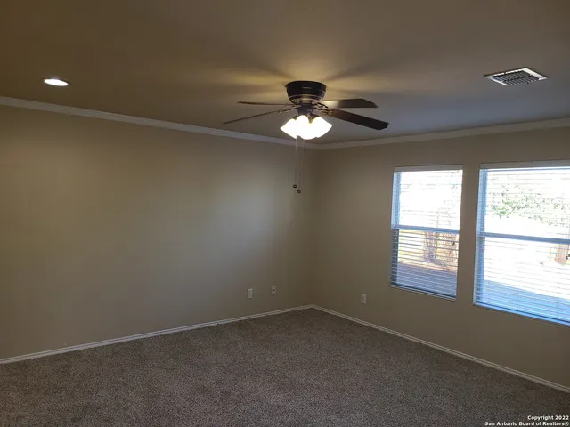 an empty room with a window and a ceiling fan