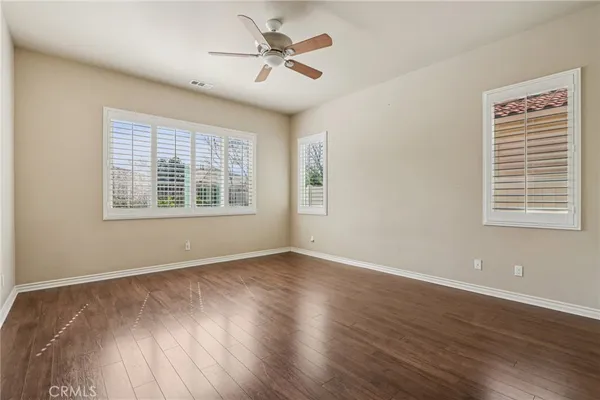 a view of a livingroom with wooden floor and a ceiling fan