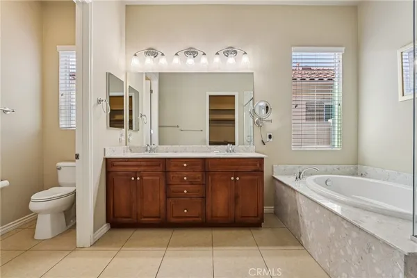 a spacious bathroom with a double vanity sink a large mirror and a bathtub