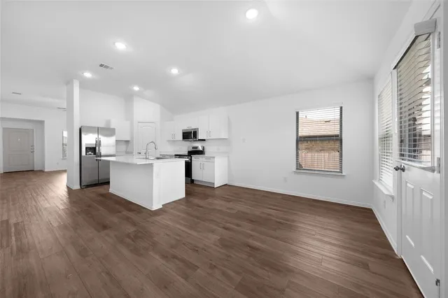 a view of kitchen with wooden floor and electronic appliances