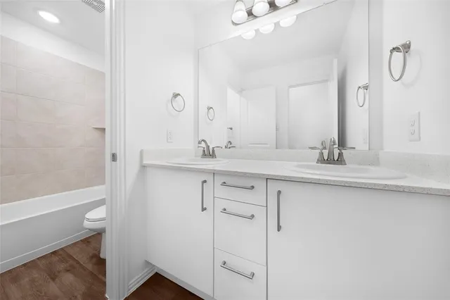a bathroom with a double vanity sink a mirror and a bathtub