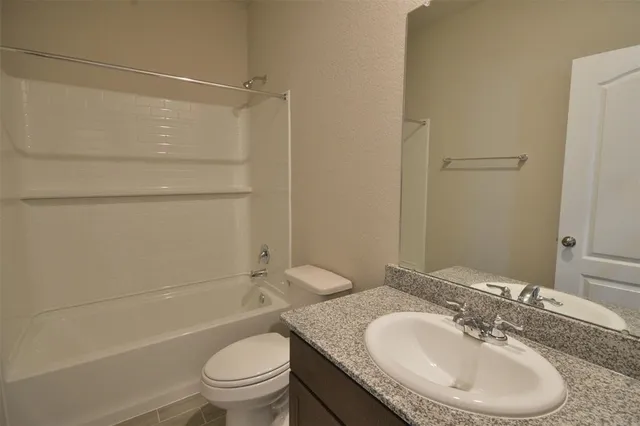 a bathroom with a granite countertop sink toilet a mirror and shower