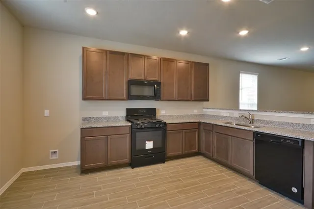 a kitchen with stainless steel appliances granite countertop a sink and cabinets