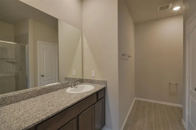 a bathroom with a granite countertop sink and a mirror