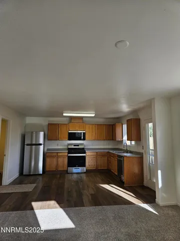 a kitchen with stainless steel appliances kitchen island granite countertop a refrigerator and stove top oven