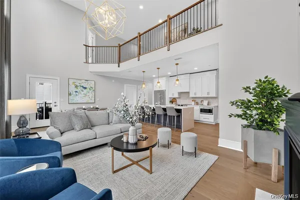a living room with furniture a chandelier and kitchen view