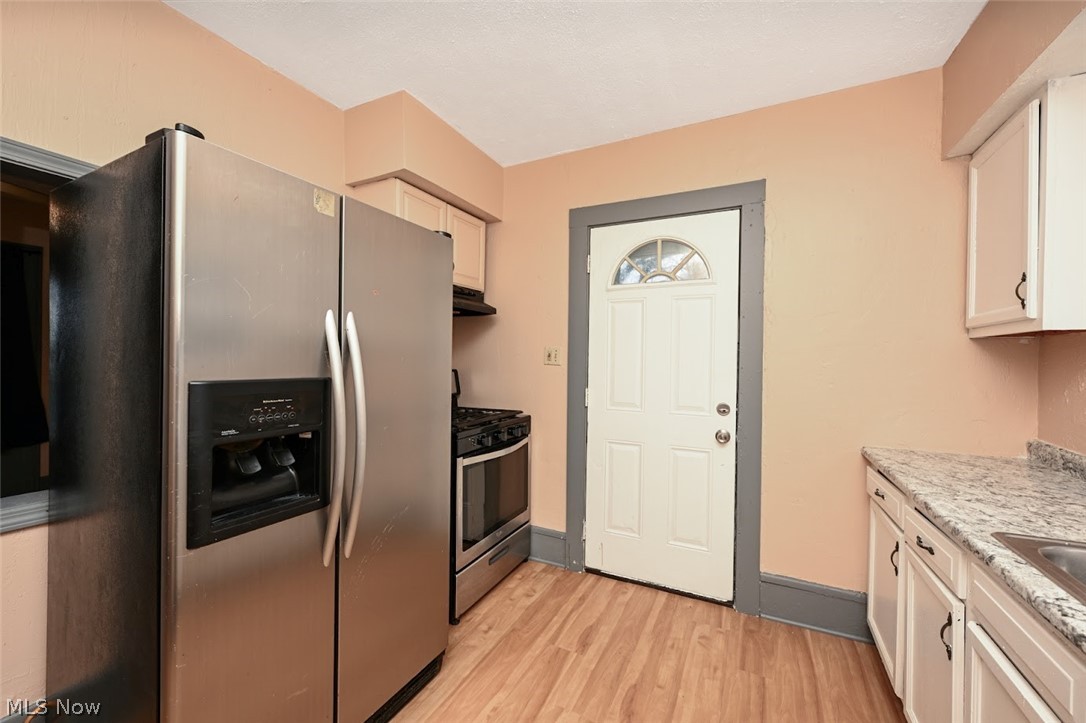 77 West Mildred Avenue Akron, OH 44310 - Photo 14 of 40 Kitchen with stainless steel appliances, light wood-style floors, light stone countertops, and white cabinetry