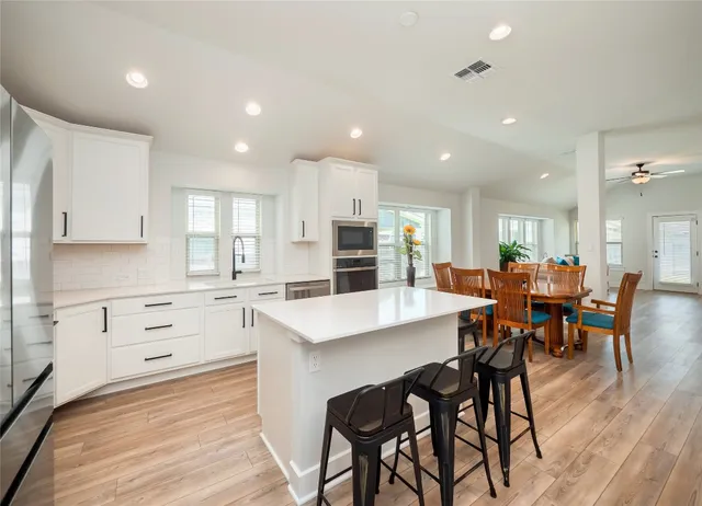 a large kitchen with cabinets table and chairs