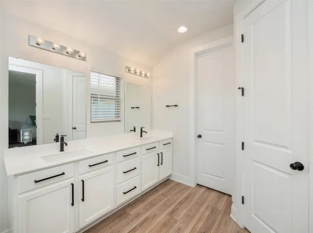 a bathroom with a double vanity sink and mirror