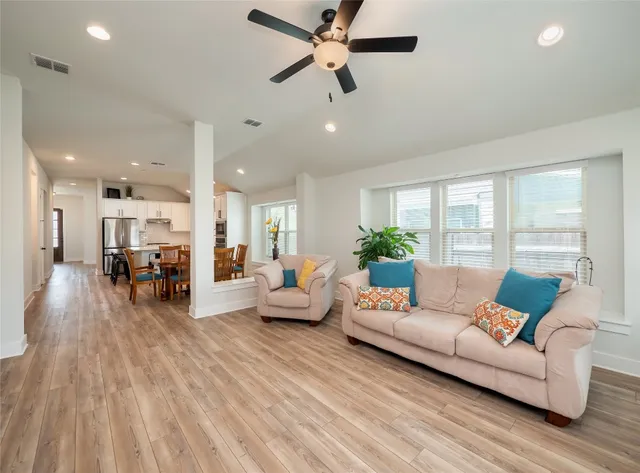a living room with furniture and a wooden floor