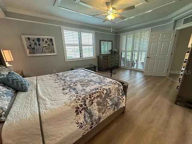 a bedroom with a large bed and a flat tv screen on dresser