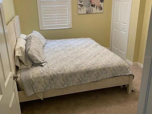 a bed sitting in a bedroom next to a window