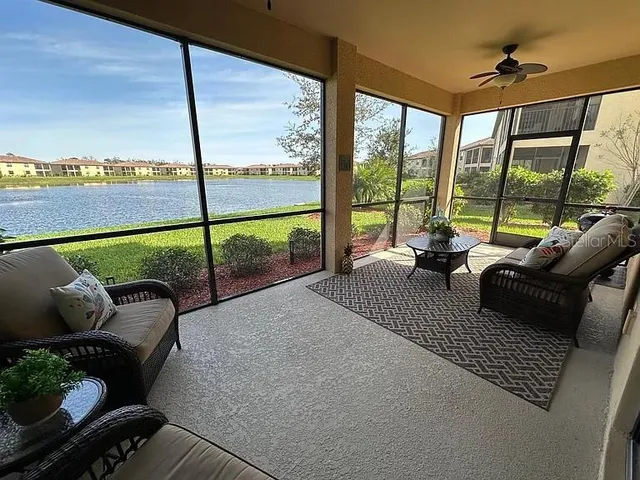 a living room with furniture and floor to ceiling windows