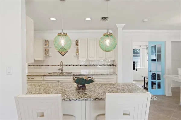 a kitchen with granite countertop a sink appliances and cabinets