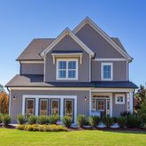 a front view of a house with yard and green space