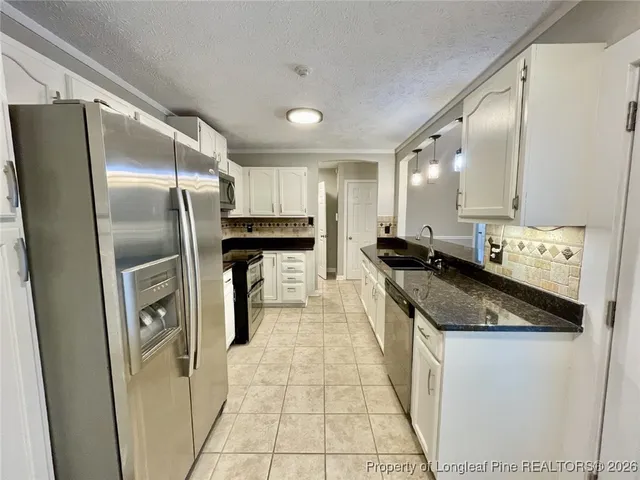 a kitchen with granite countertop a stove and a sink