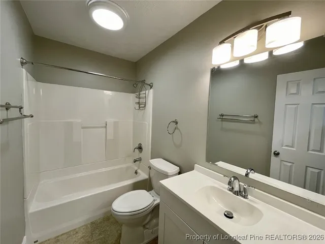 an empty room with wooden floor and fan