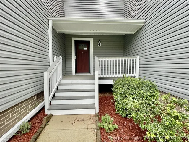 a view of a house with a small door and potted plants