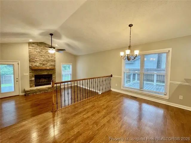 a view of a livingroom with wooden floor and a fireplace