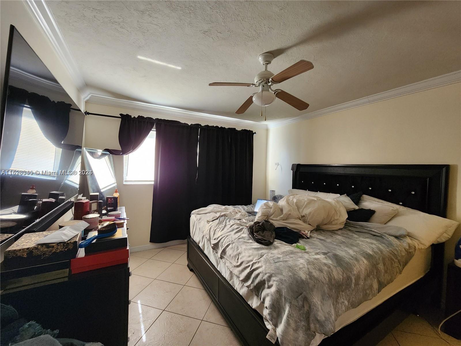 California Club Miami, FL 33179 - Photo 5 of 6 a bedroom with a bed and a ceiling fan