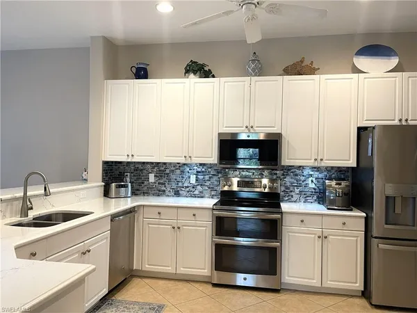 a kitchen with white cabinets and stainless steel appliances