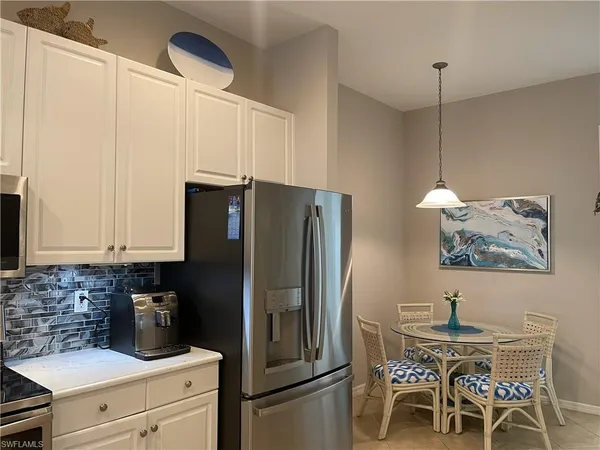 a kitchen with stainless steel appliances a refrigerator a stove a sink and white cabinets