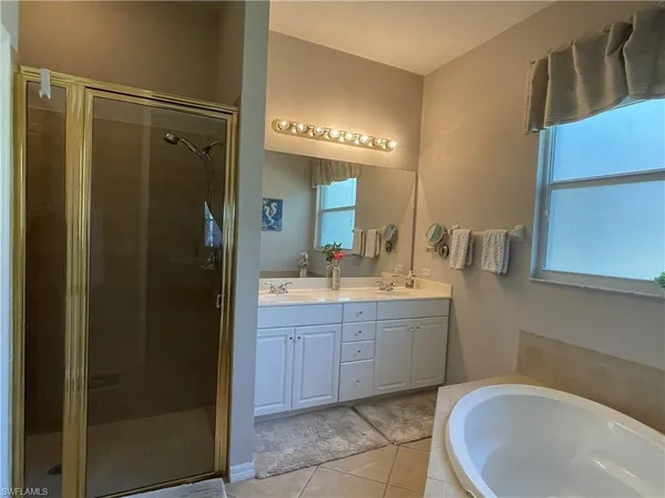 a bathroom with a bathtub sink vanity and mirror