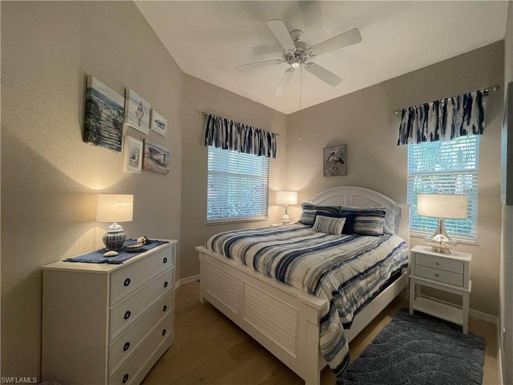 3532 Periwinkle Way, Unit 11 Naples, FL 34114 - Photo 21 of 37 a bedroom with a bed and a chandelier
