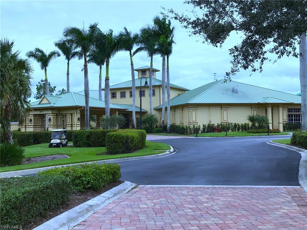3532 Periwinkle Way, Unit 11 Naples, FL 34114 - Photo 23 of 37 a front view of a house with a yard and garage