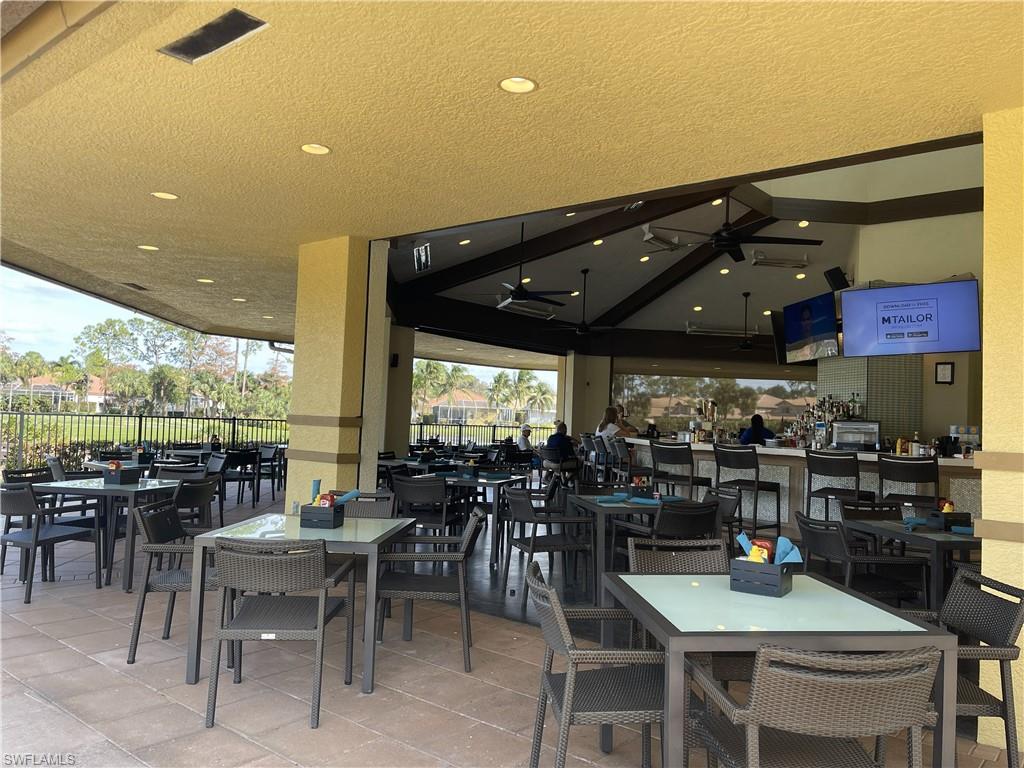 3532 Periwinkle Way, Unit 11 Naples, FL 34114 - Photo 29 of 37 a view of a dining area with furniture and chandelier