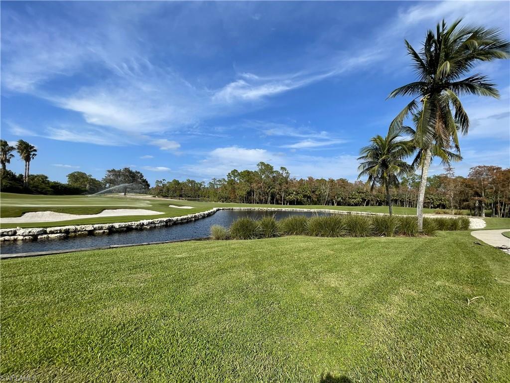 3532 Periwinkle Way, Unit 11 Naples, FL 34114 - Photo 34 of 37 a view of a lake with a house in the background