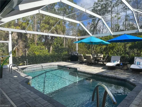 a view of backyard with swimming pool and outdoor seating